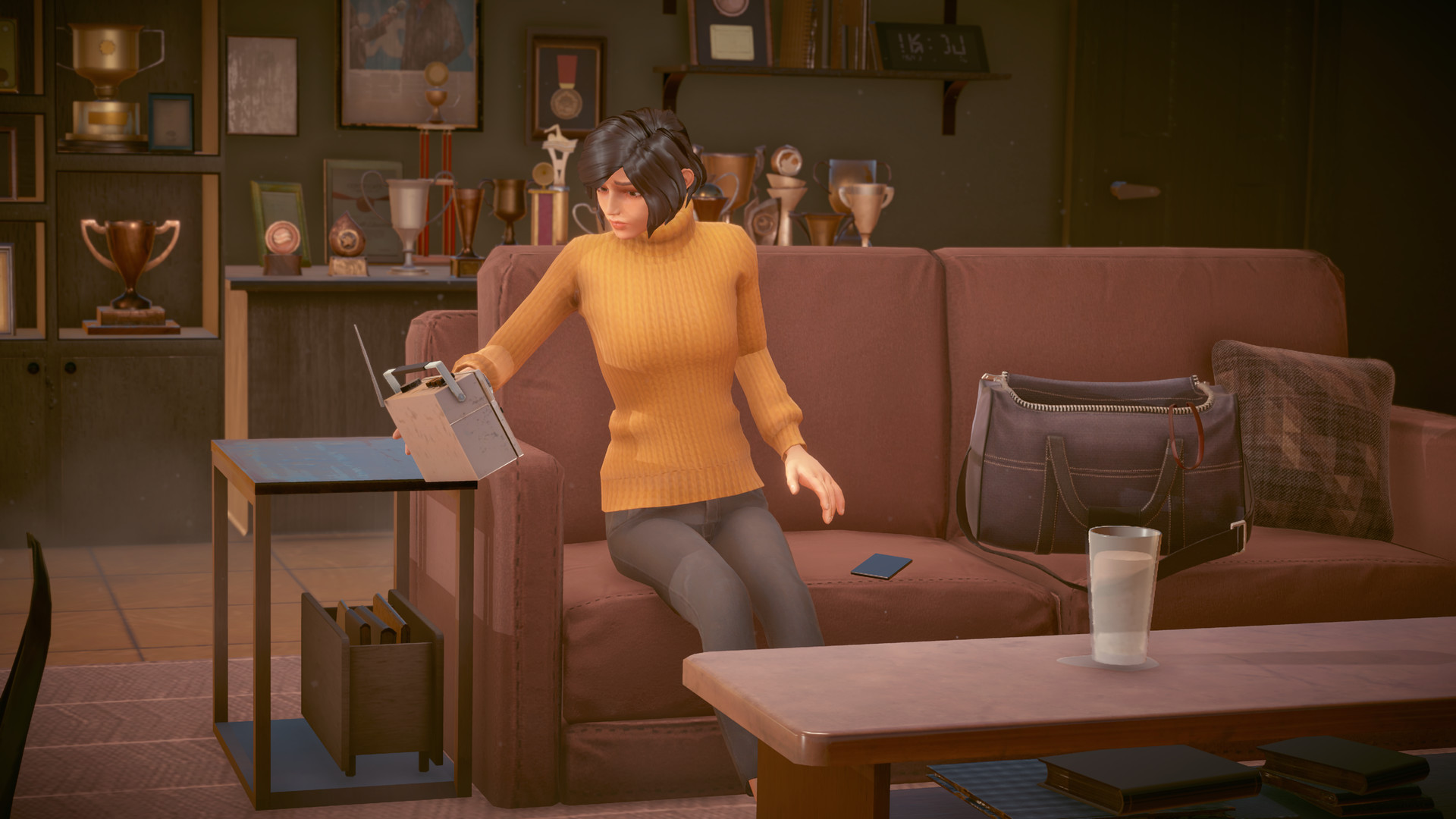 Miriam sits in a room filled with swimming trophies.