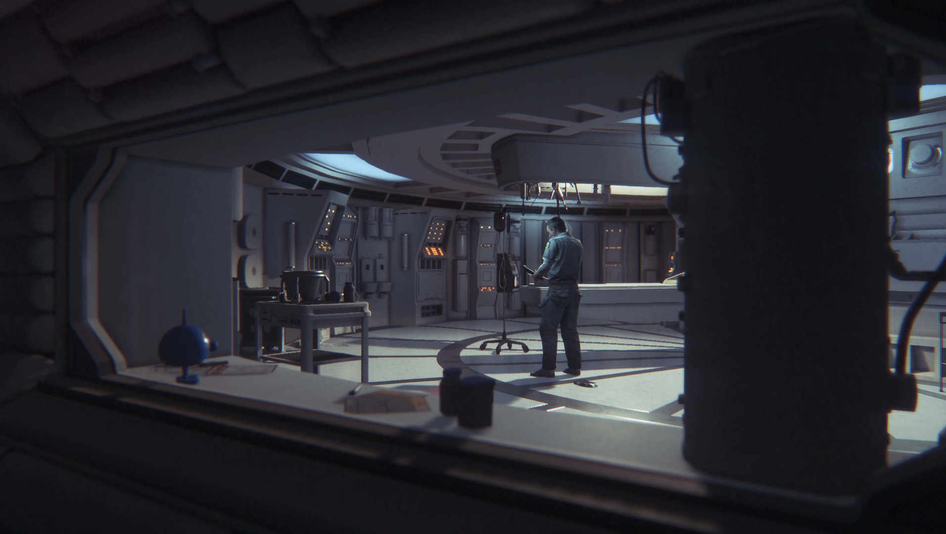 A humanoid figure stands inside a station room.