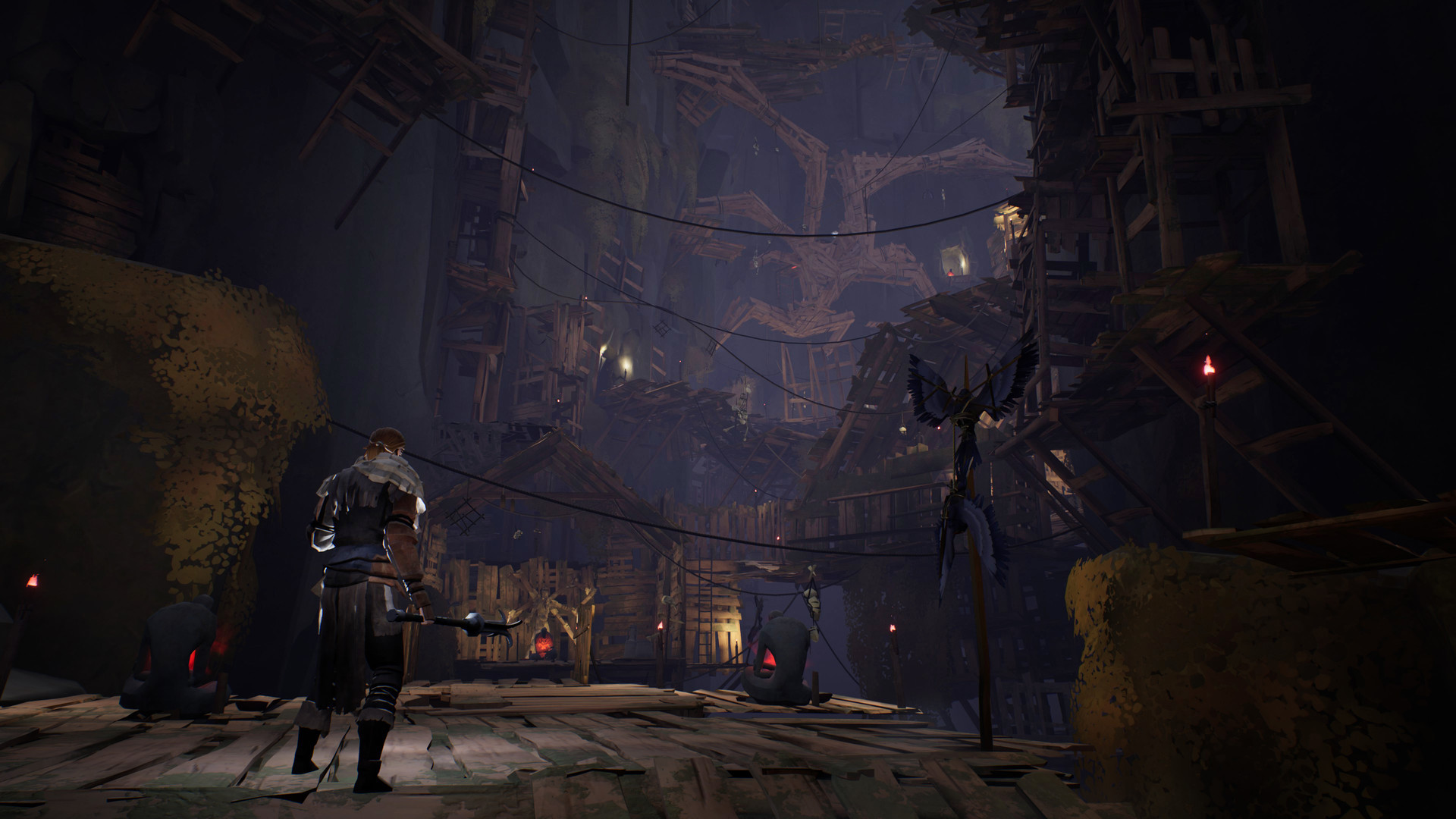 A traveller enters a timber-built settlement beneath a cavern roof.