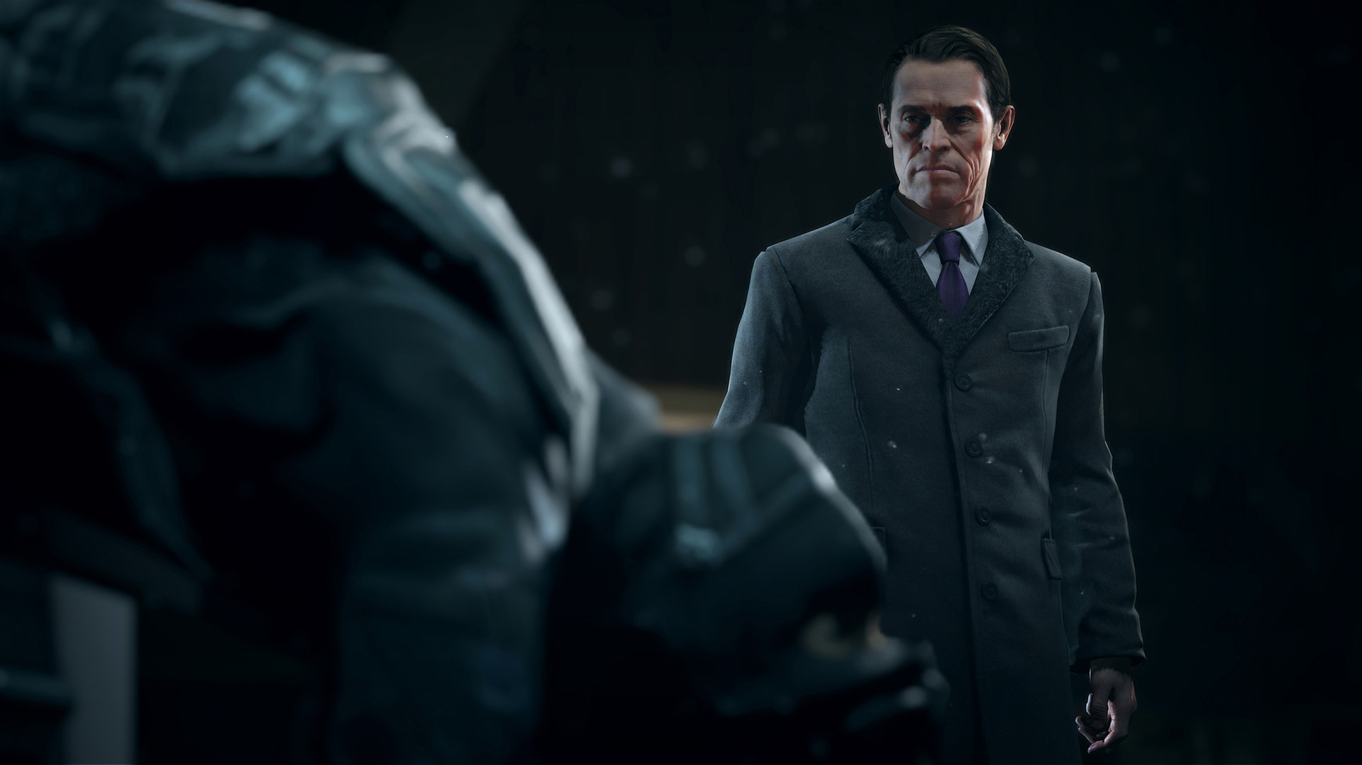 A suited man faces a figure in a dark room.