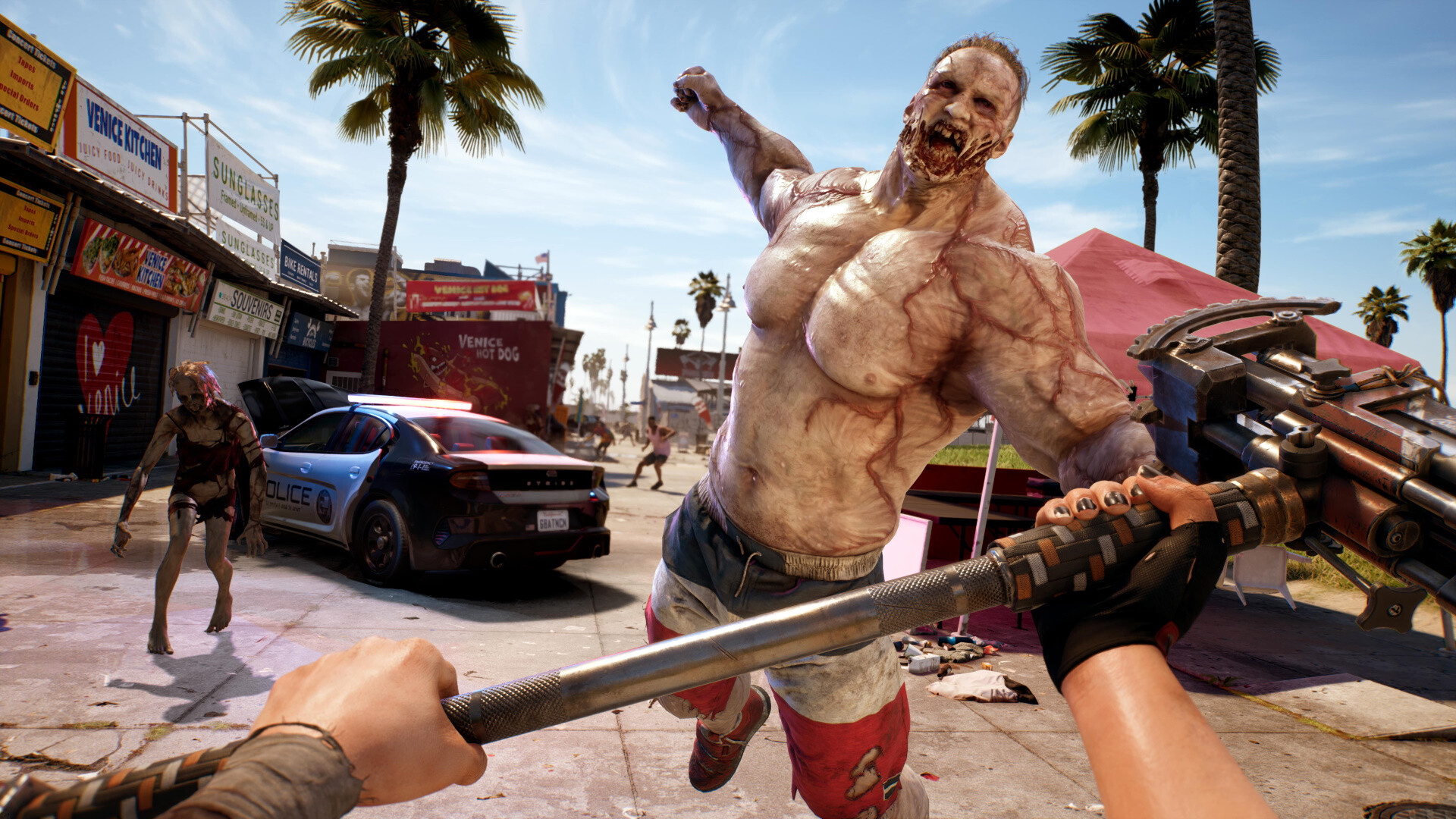 A slayer strikes a charging zombie on a sunny Los Angeles street.