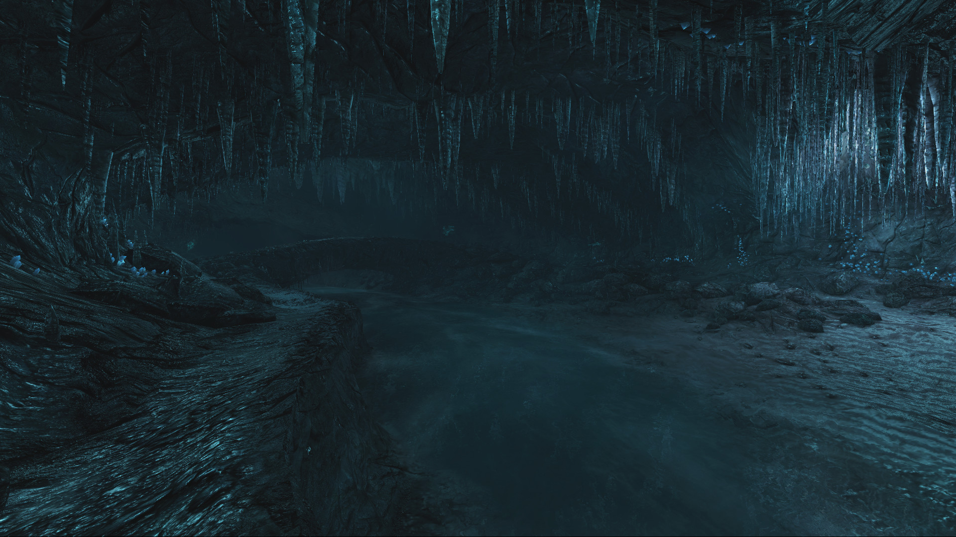 A dark cave opens beyond a wet passage.