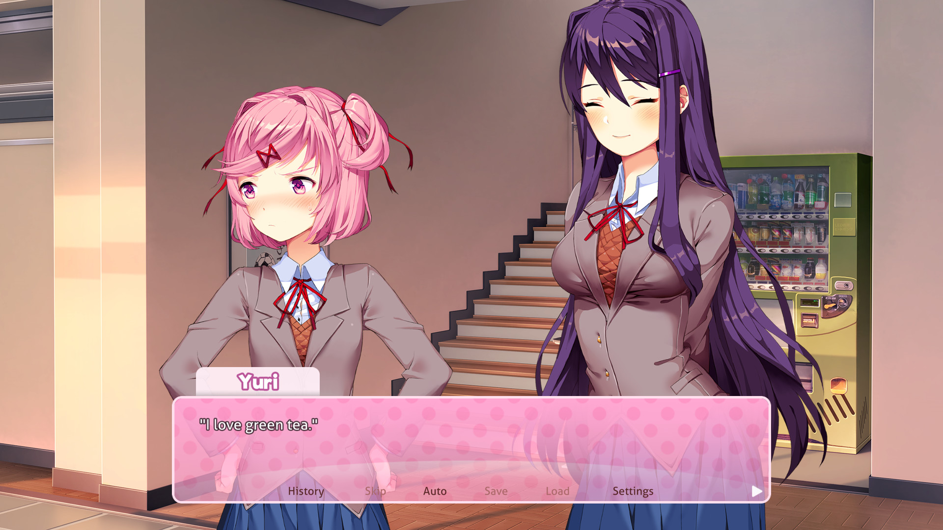 Two club members speak beside a school stairway.