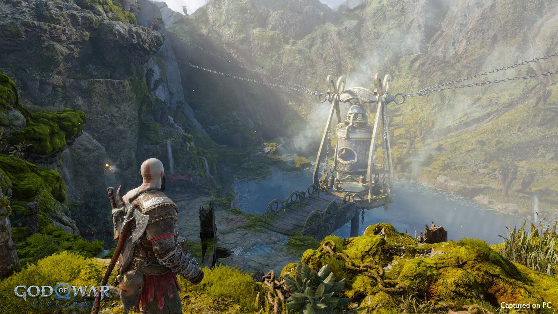 Kratos approaches a mechanism beside a mountain stream.
