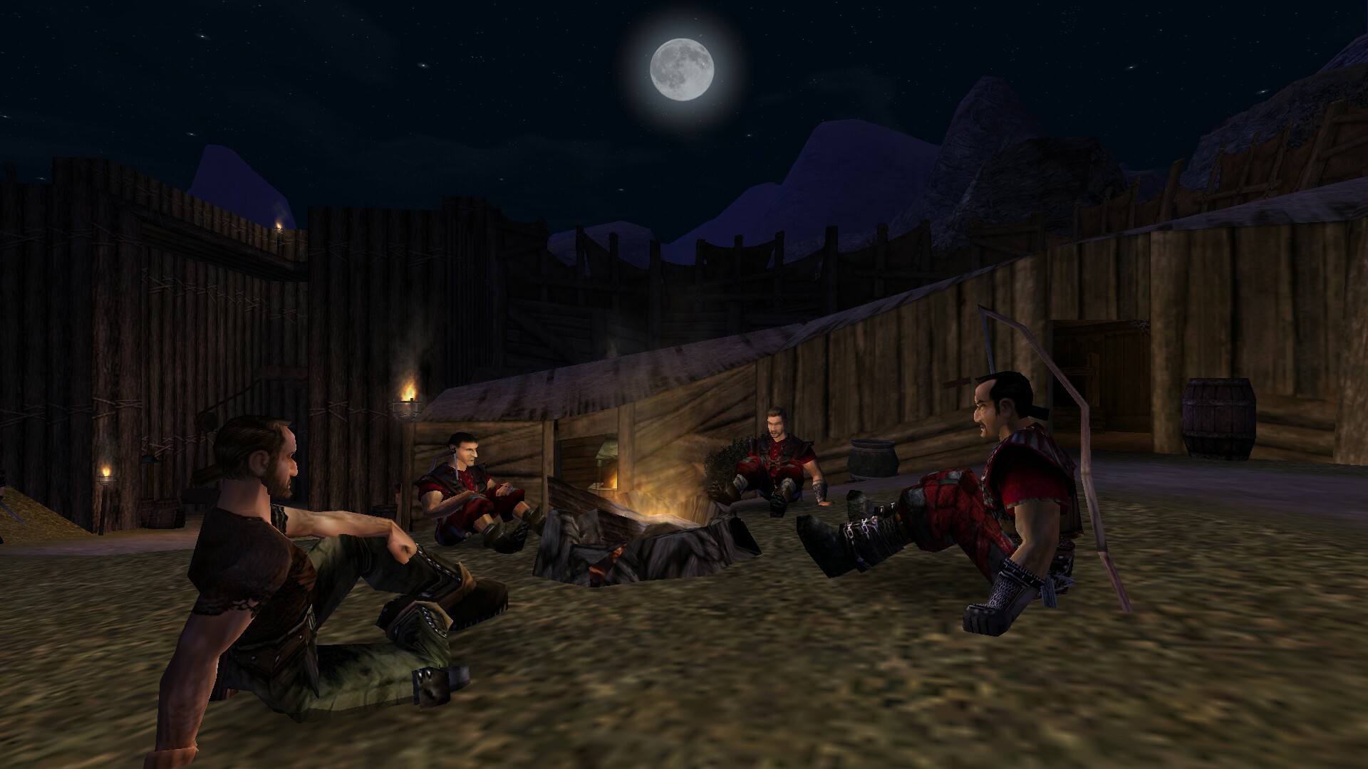 Camp members gather around a fire under the moon.