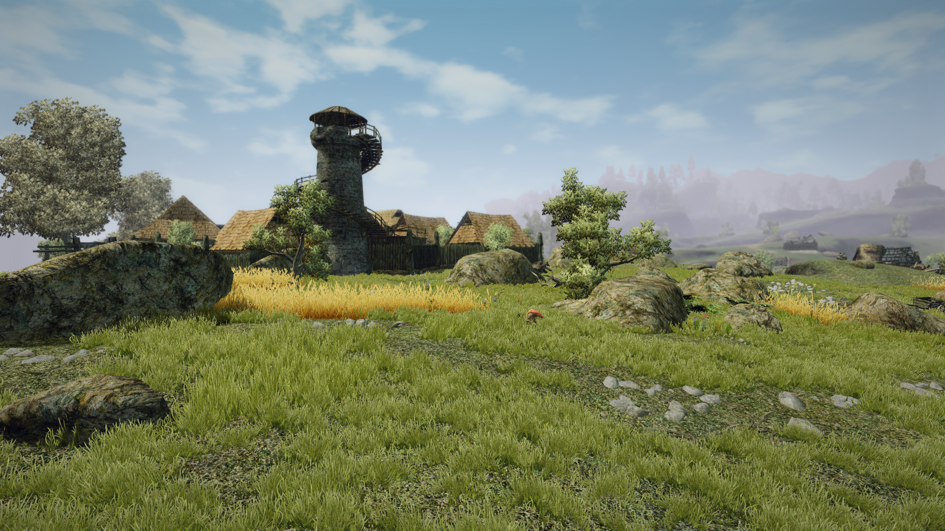 A village sits beyond a grassy field.