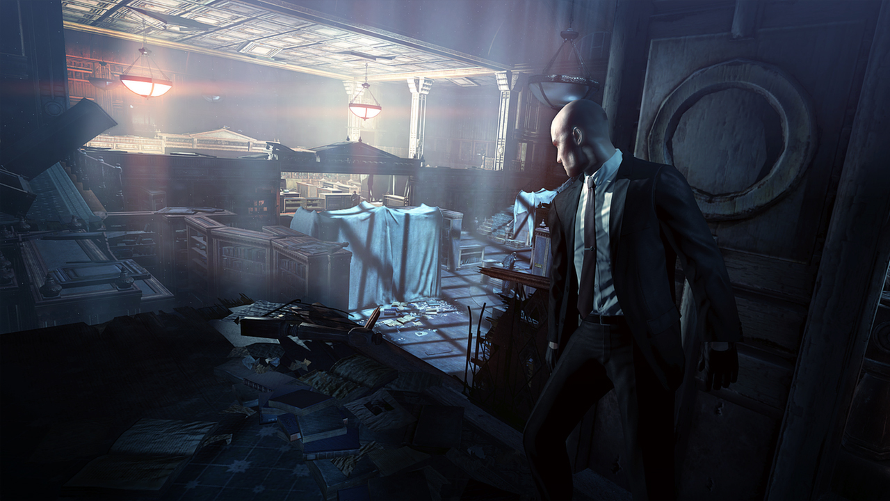 Agent 47 moves through a damaged interior.