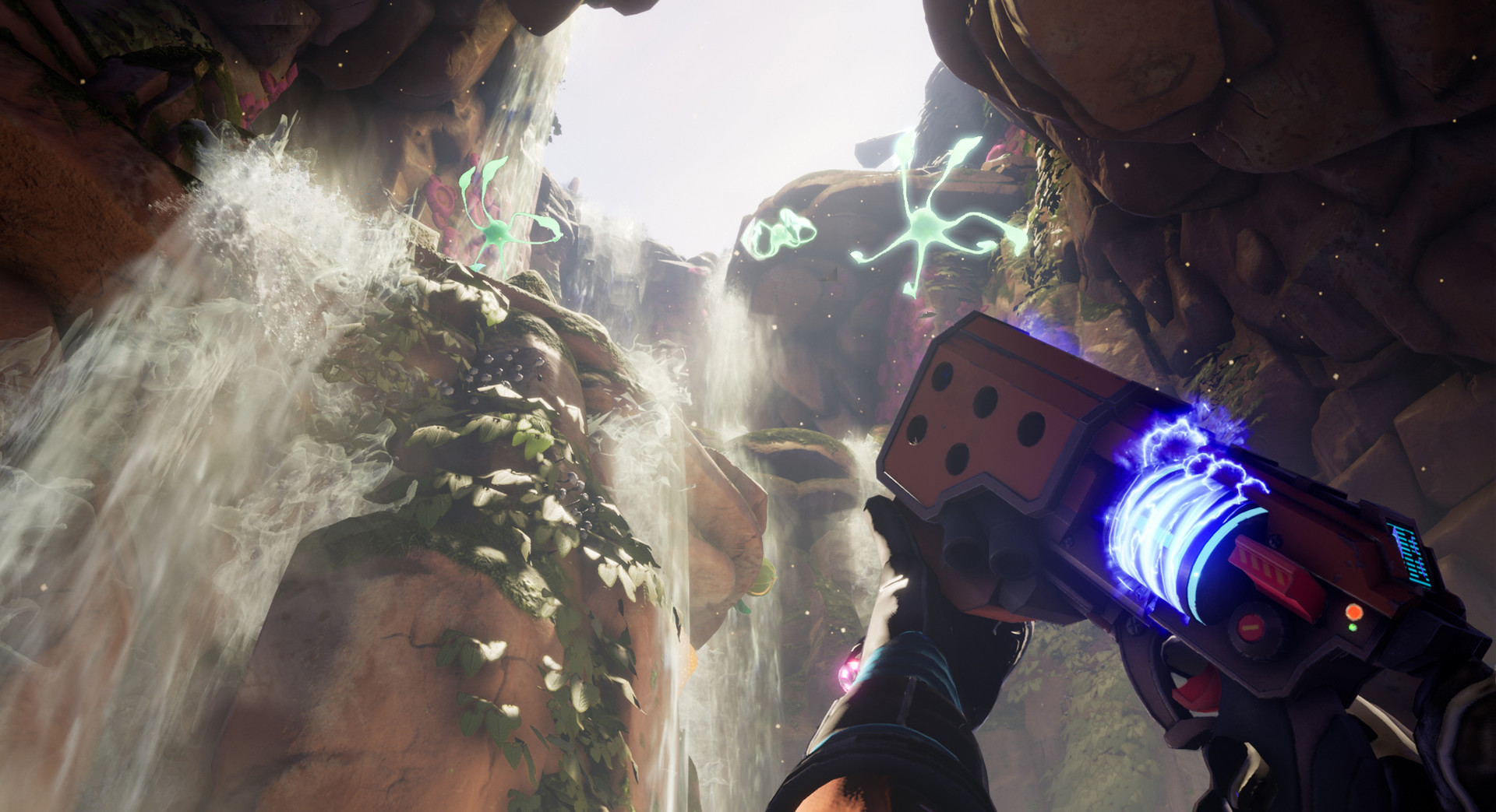 The explorer aims a tool inside a rocky cave with a waterfall.