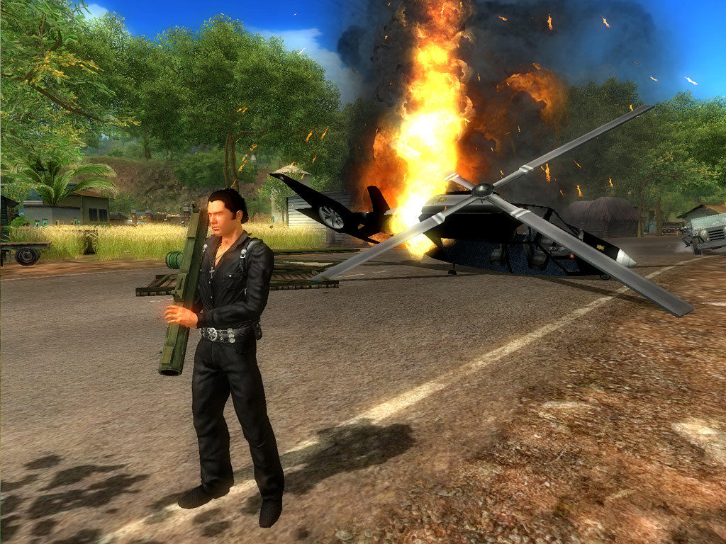 Rico stands near an aircraft wreck in a tropical settlement.