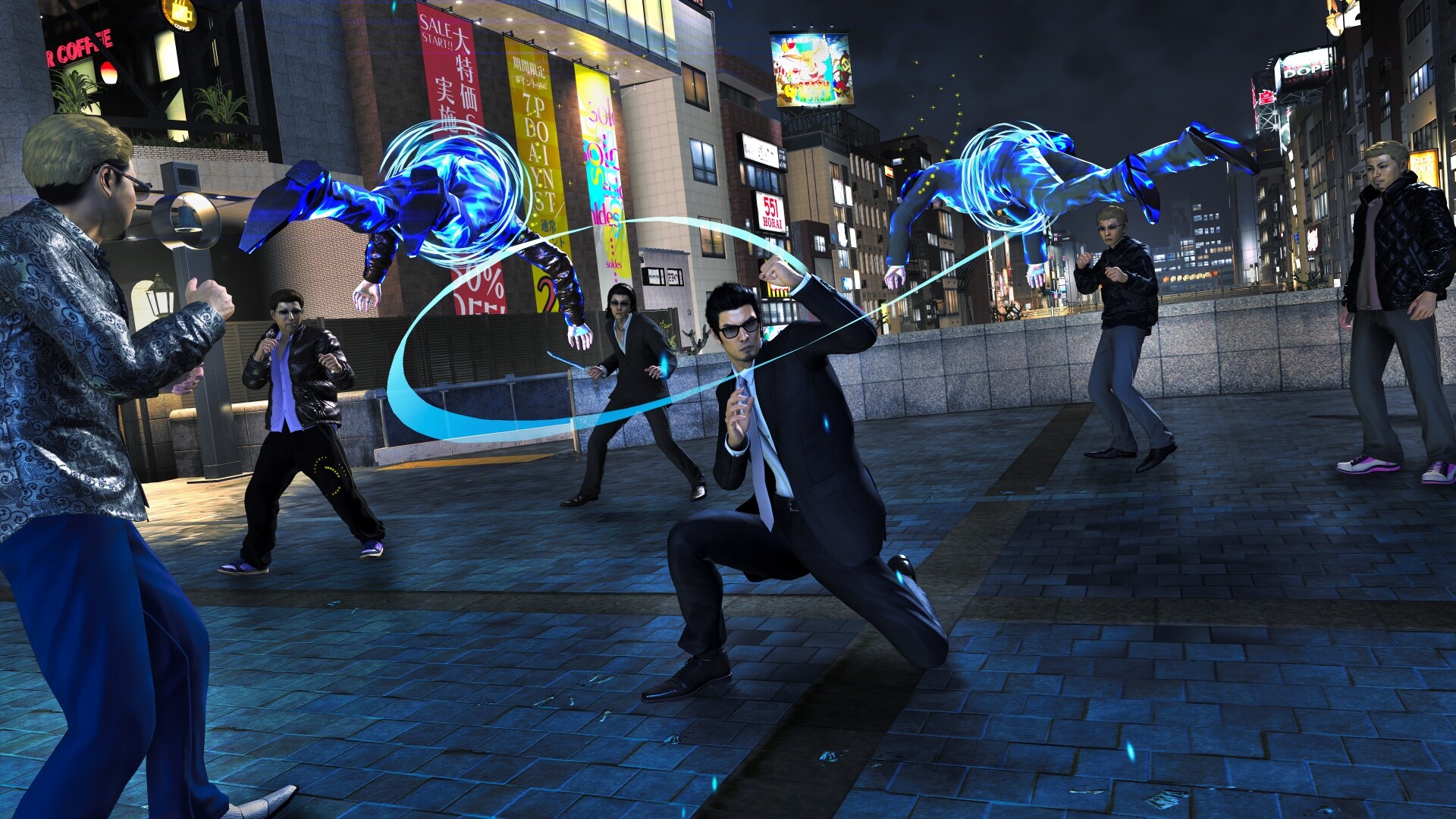 Kiryu faces attackers in a city street as blue energy arcs around him.