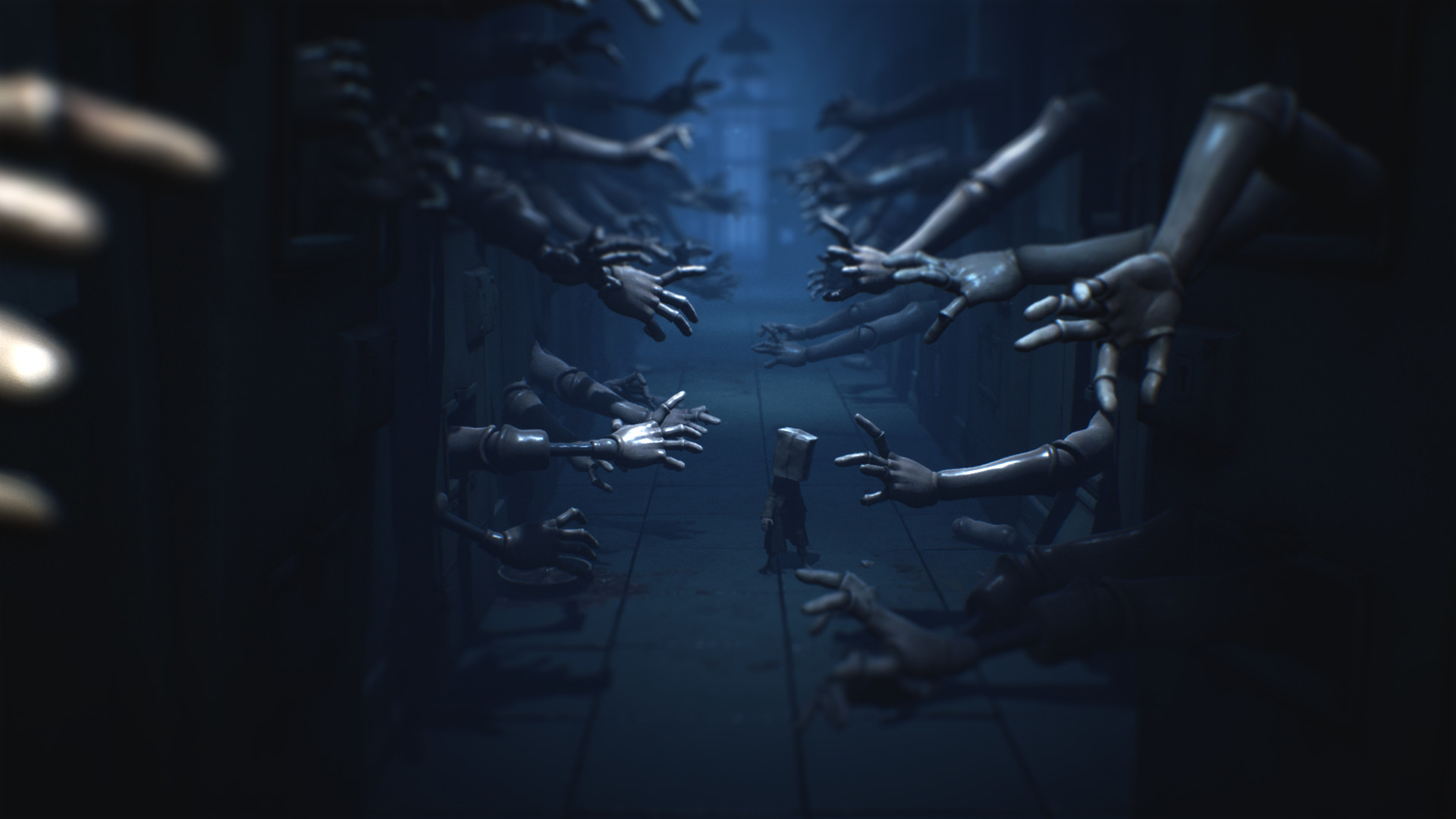 A small figure passes a corridor lined with reaching mannequin arms.