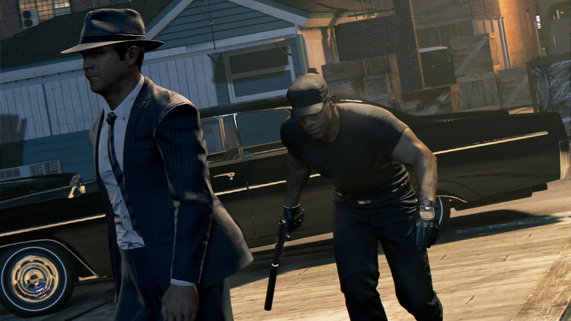 Two men move past a vehicle with guns drawn.