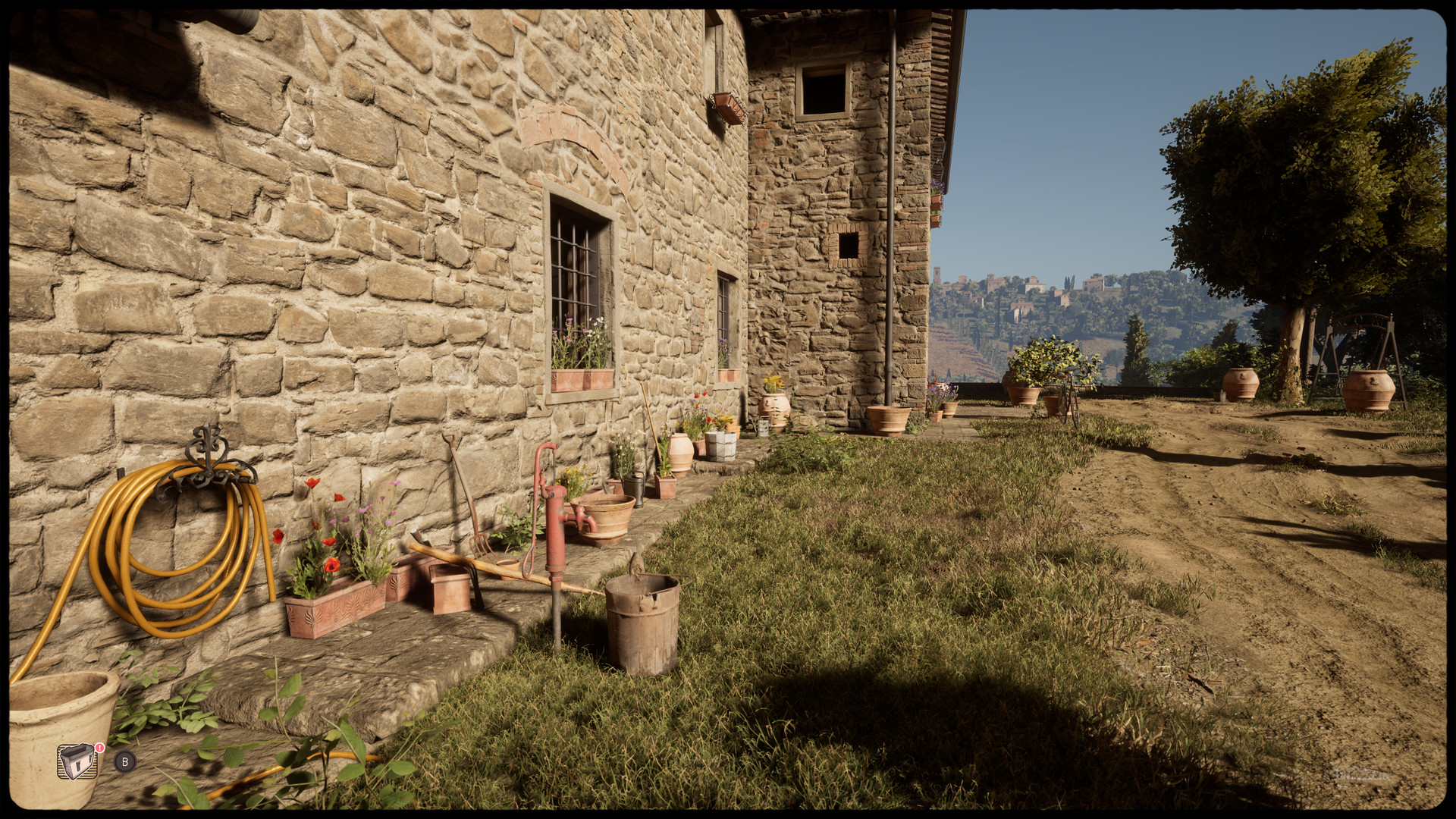 A stone farmhouse and garden sit in bright sunlight.