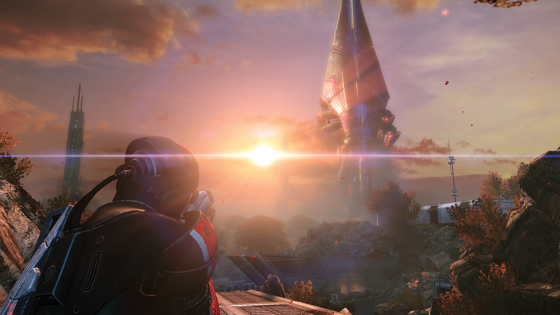 An armoured figure overlooks an alien landscape at sunset.