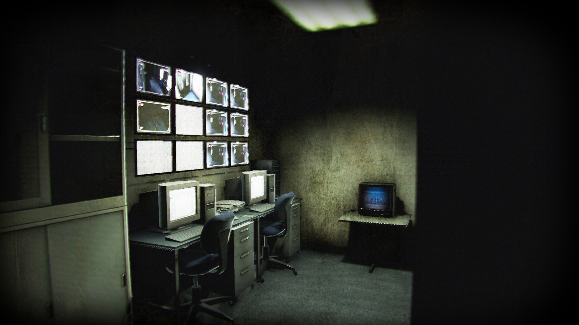 Security monitors and computers fill a dark office room.