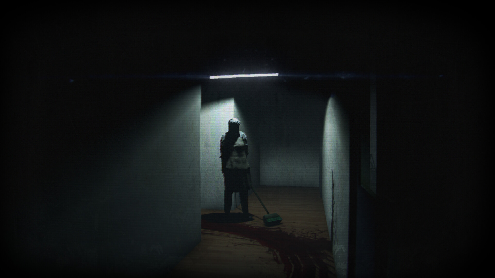 A figure stands in a dim office corridor beside a broom and dark stain.