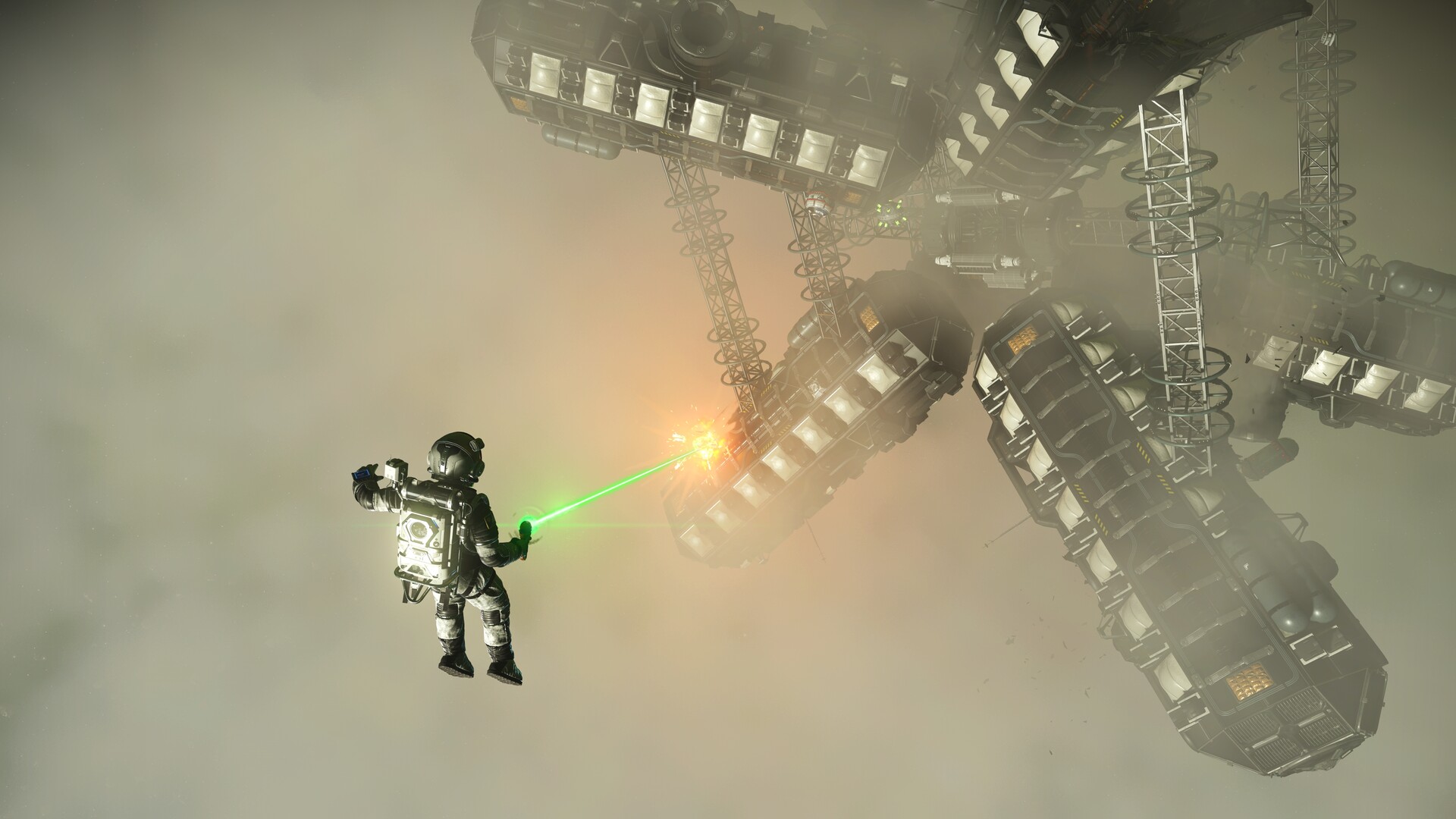 An astronaut drifts beside a large structure in space.