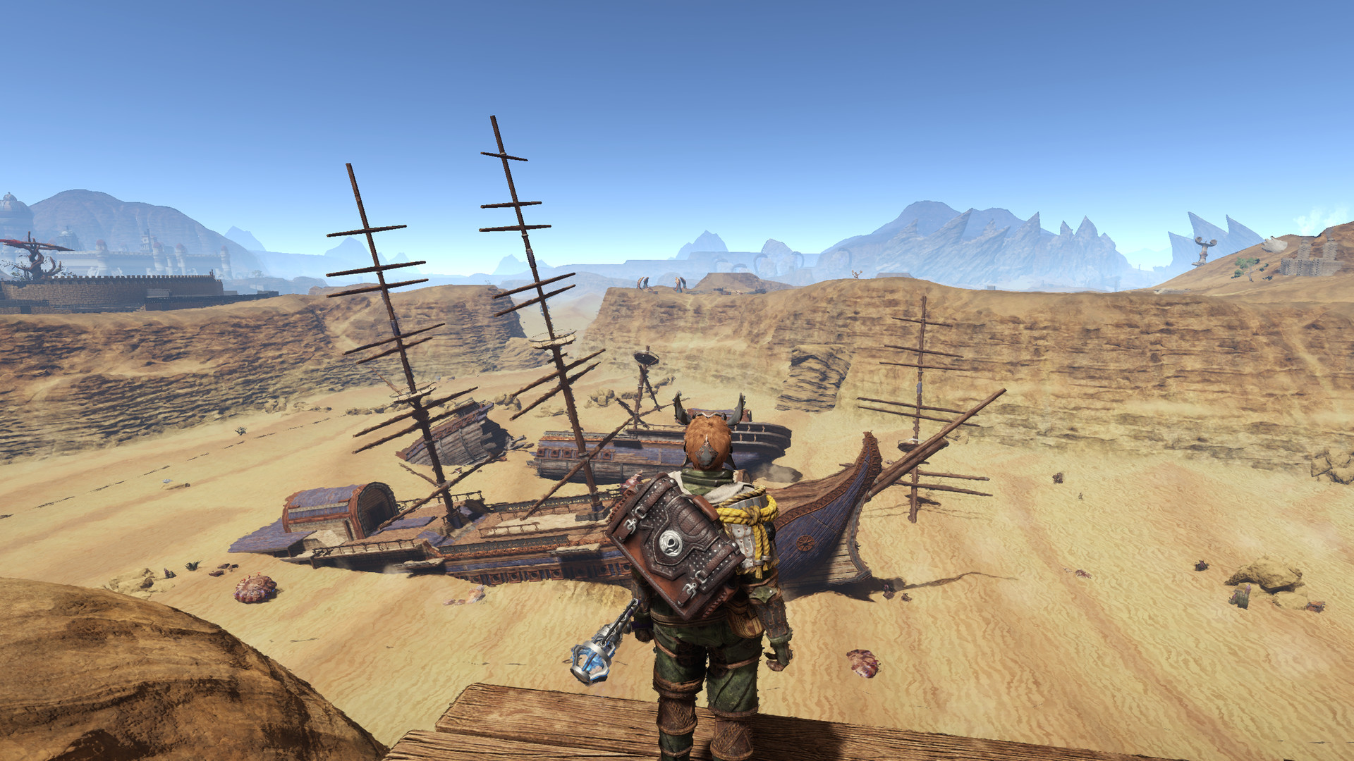 An equipped traveller approaches a wrecked ship on a desert shore.