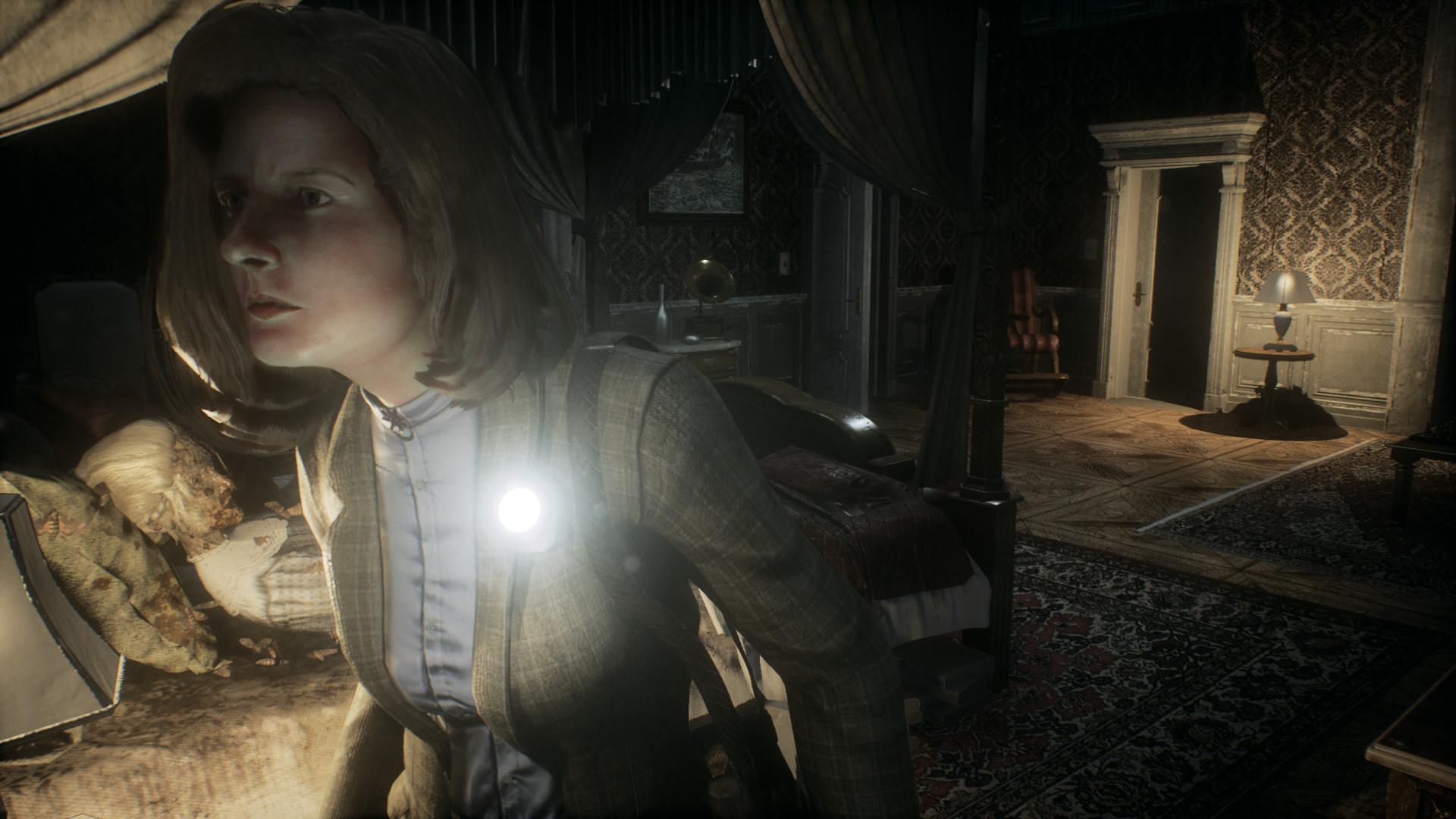 Rosemary Reed carries a light through a furnished room.