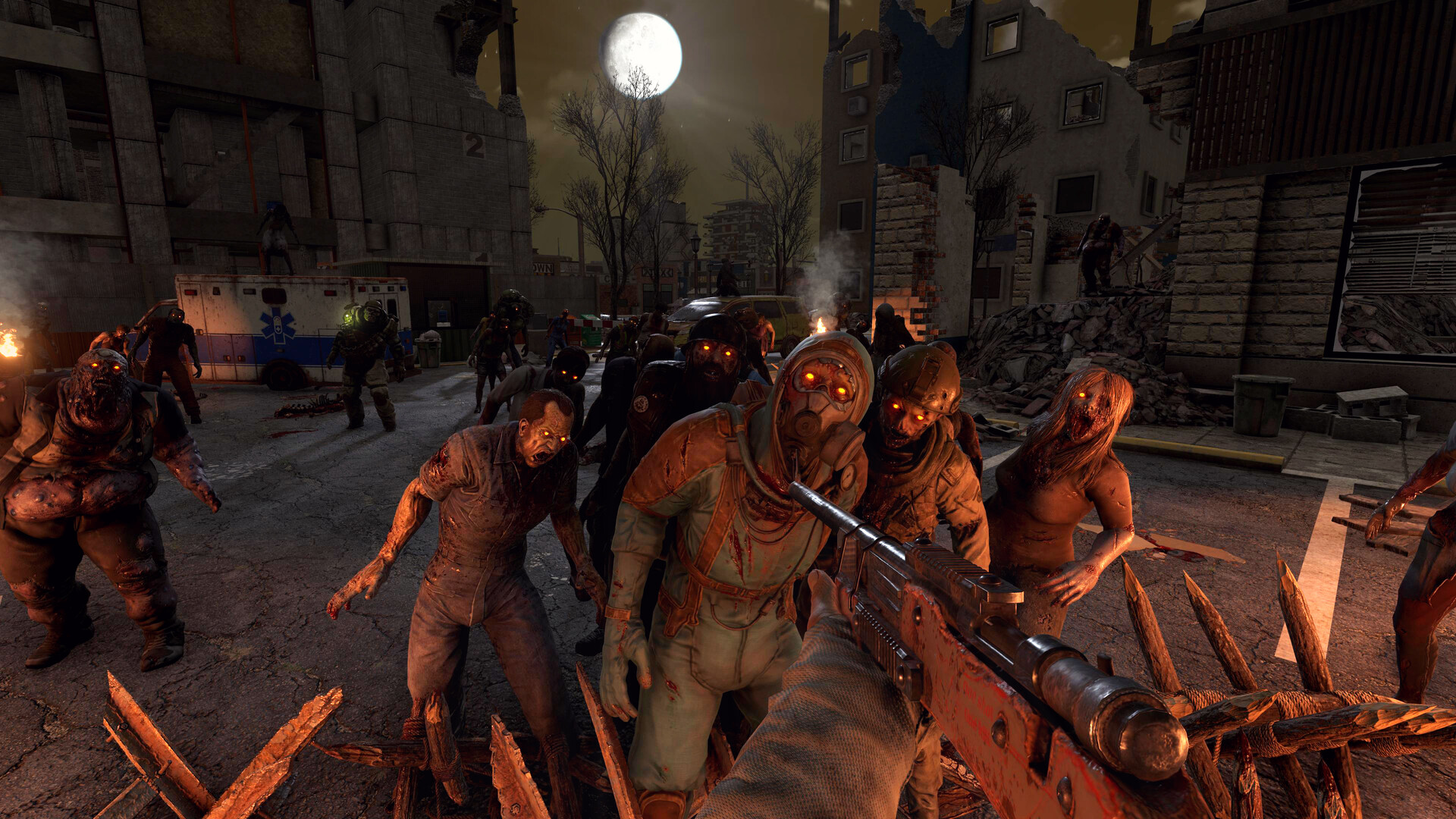 A horde of infected approaches a barricade at night.