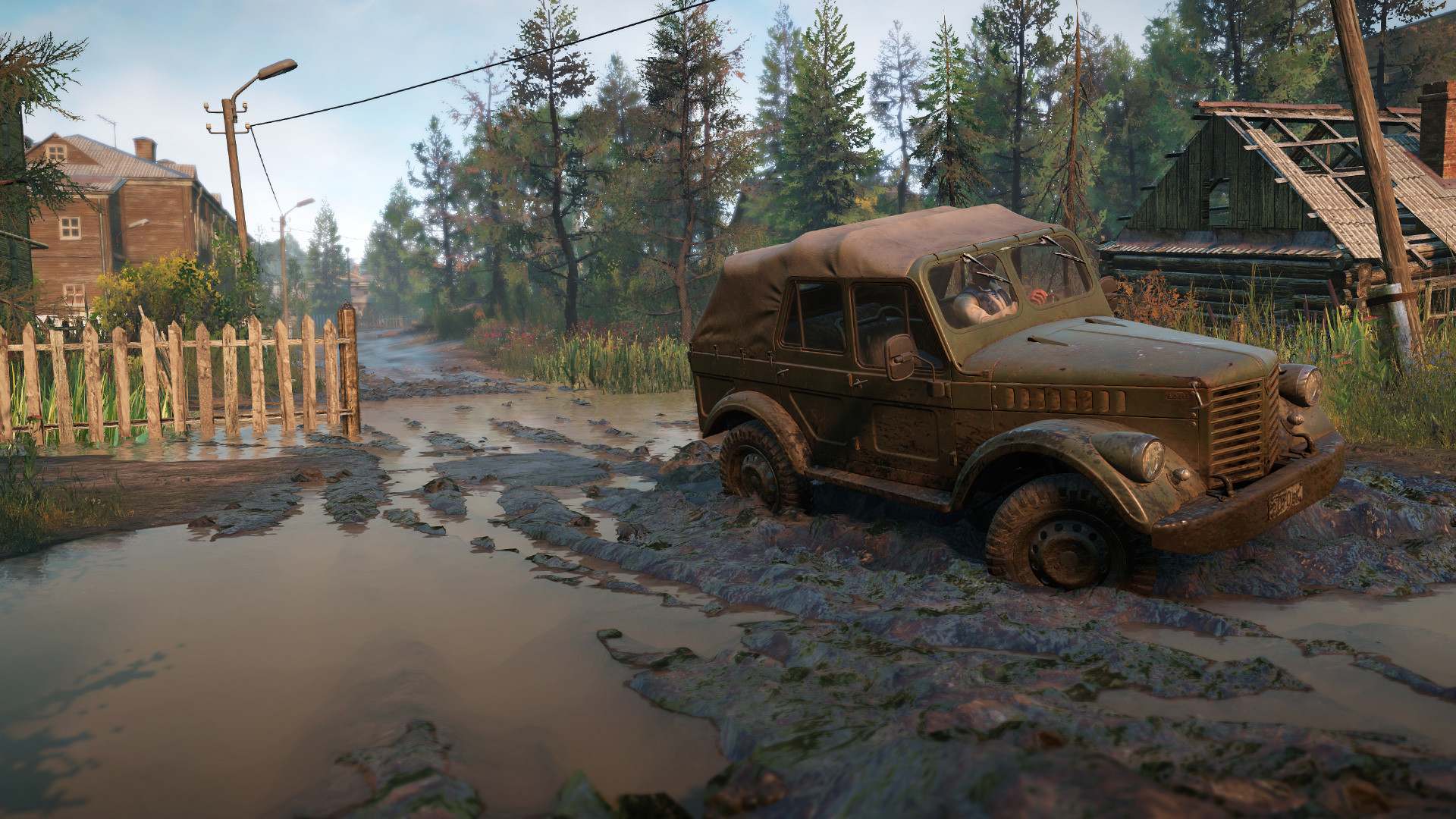 An off-road truck pushes through a muddy road.