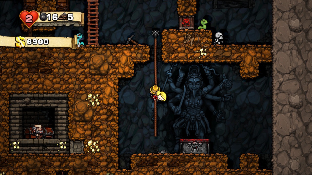 An explorer descends on a rope beside a stone statue.
