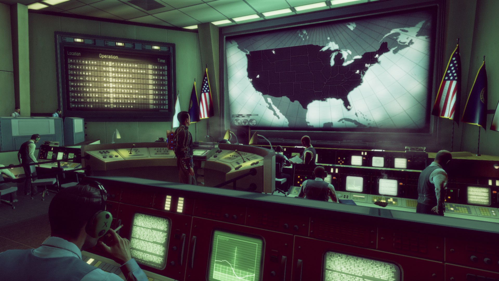 Bureau staff work in a command room beneath a map of the United States.
