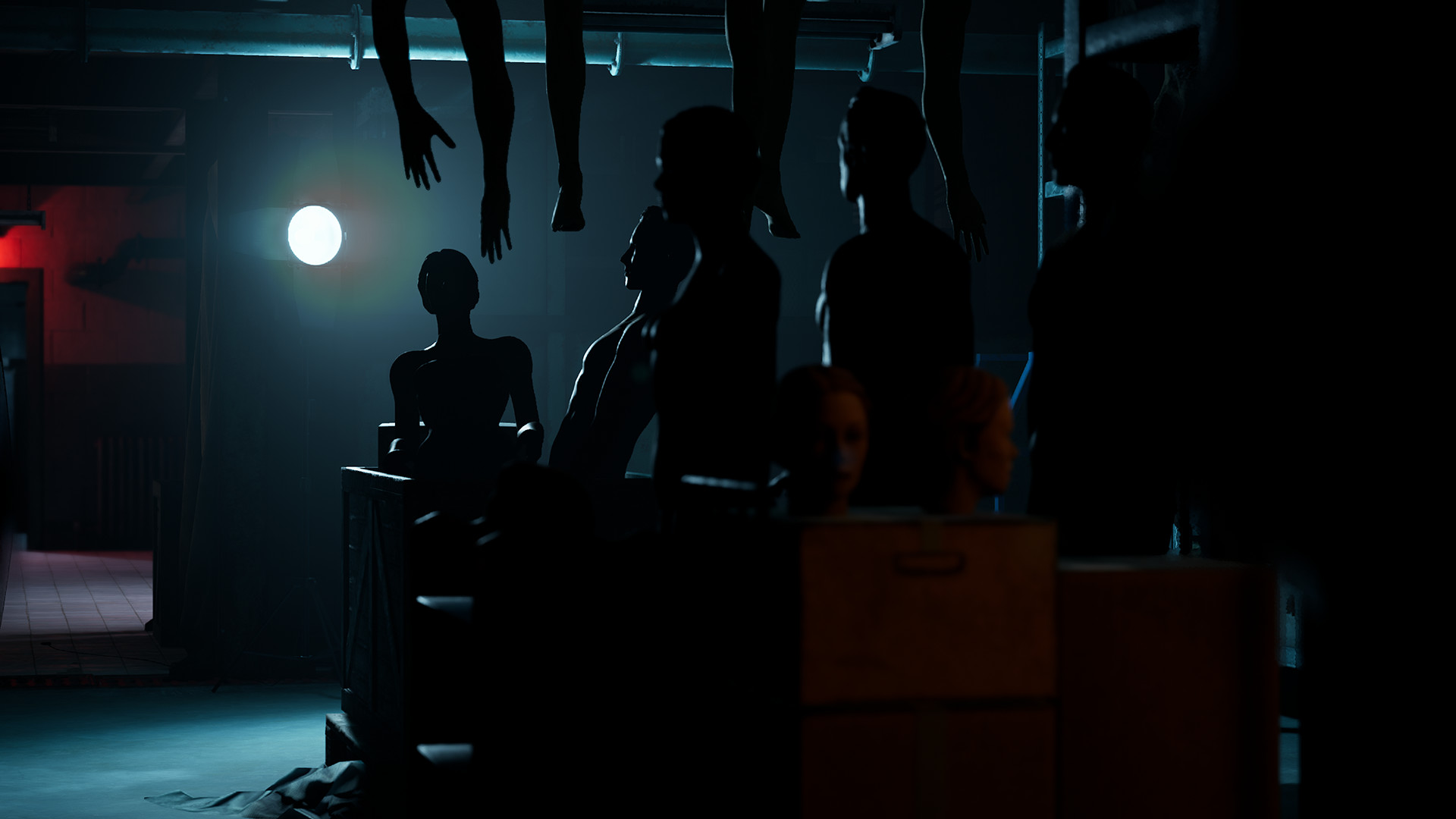 Human-shaped figures and hanging limbs fill a dark room.