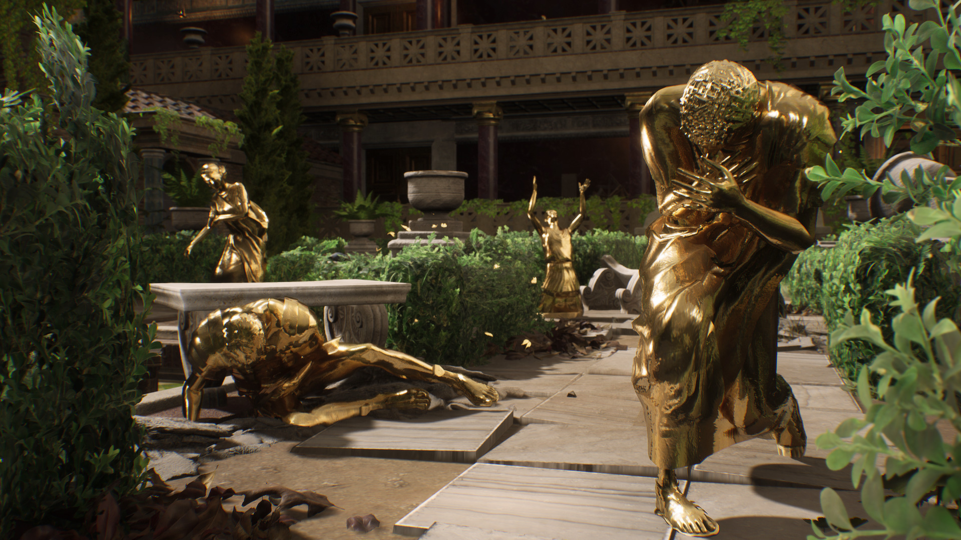 Golden statues stand in a planted courtyard.