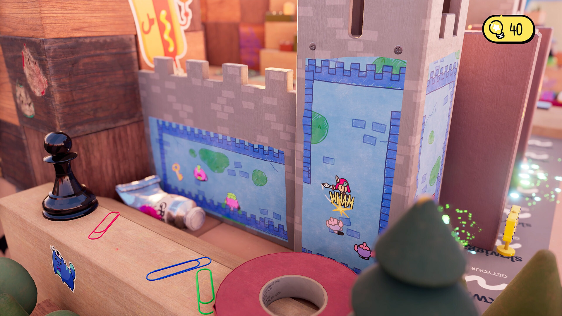 The hero crosses a cardboard castle turret on a desktop.