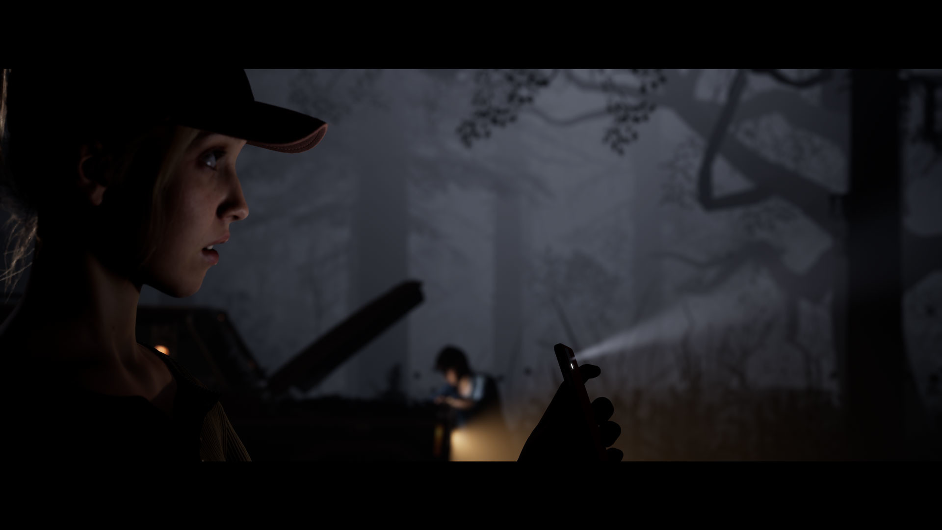 A counsellor holding a phone looks into a misty woodland.