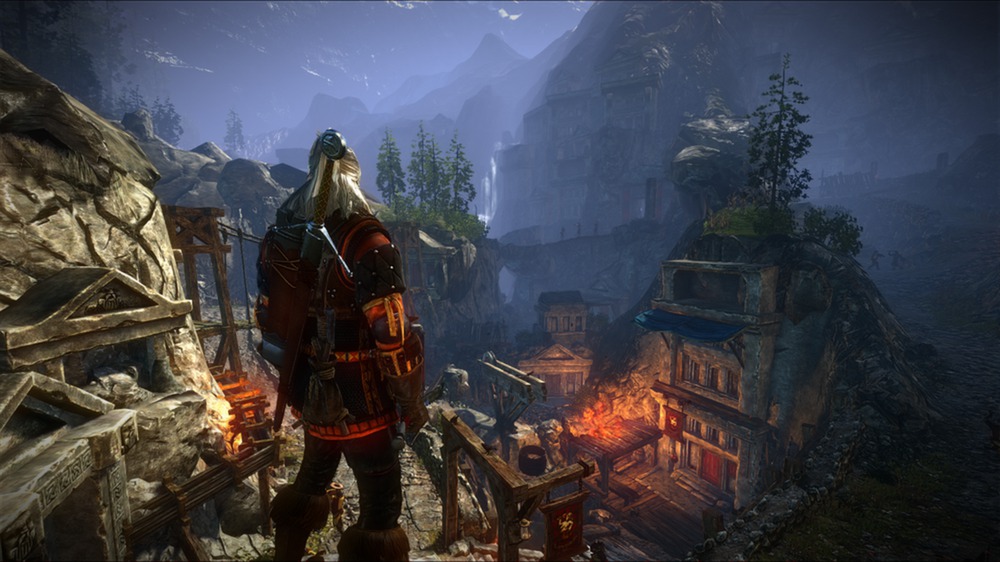 Geralt overlooks a mountain settlement at dusk.