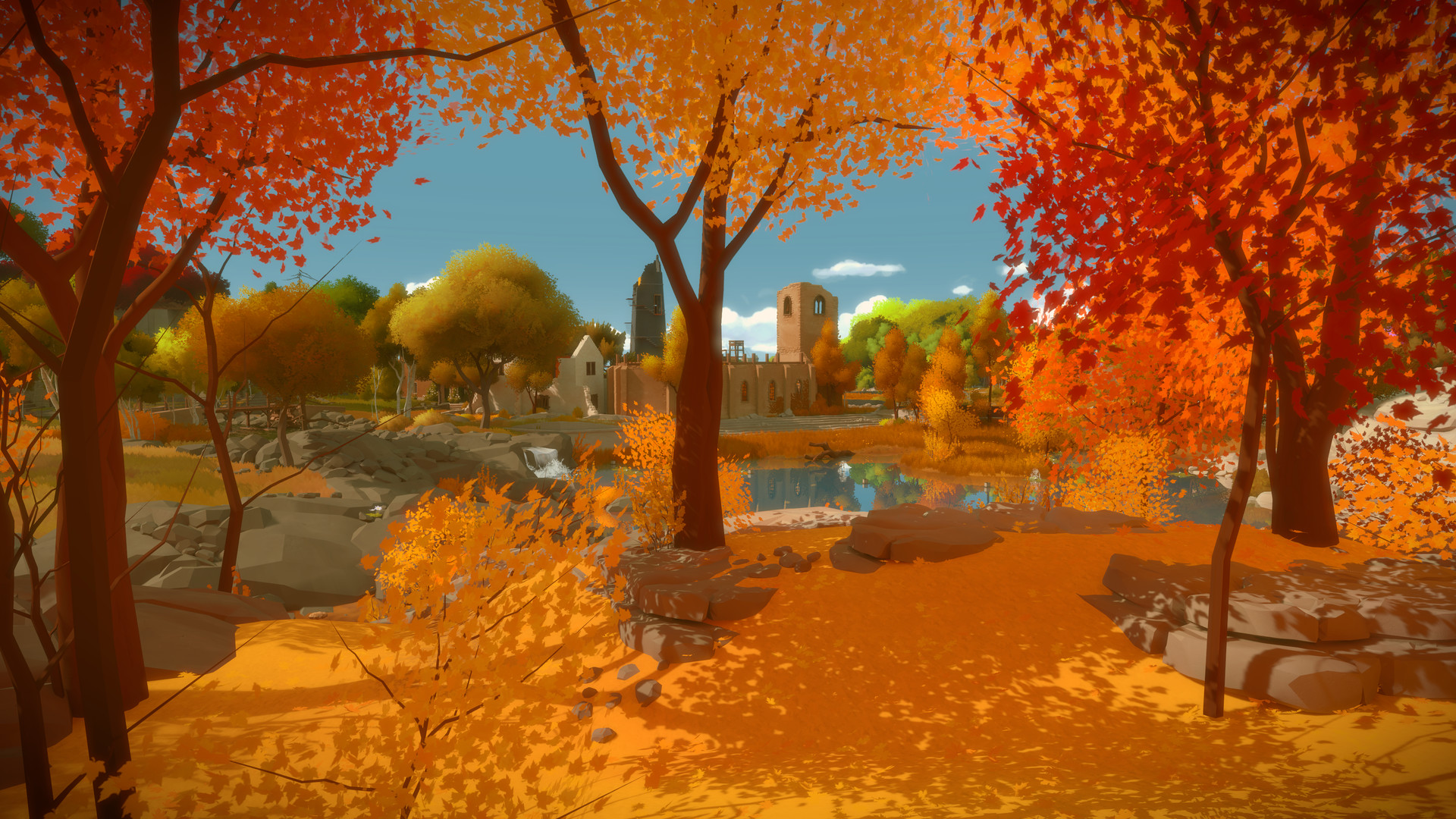 An autumn path winds through the island beside a pond.