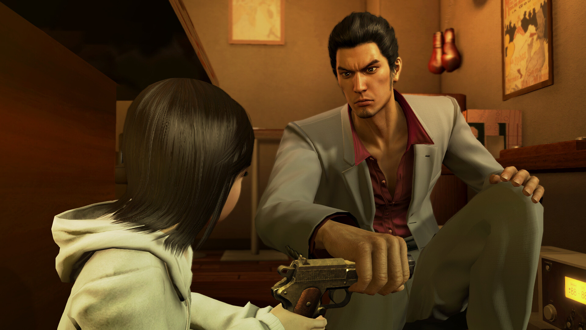 Kiryu speaks with a young girl inside a small room.